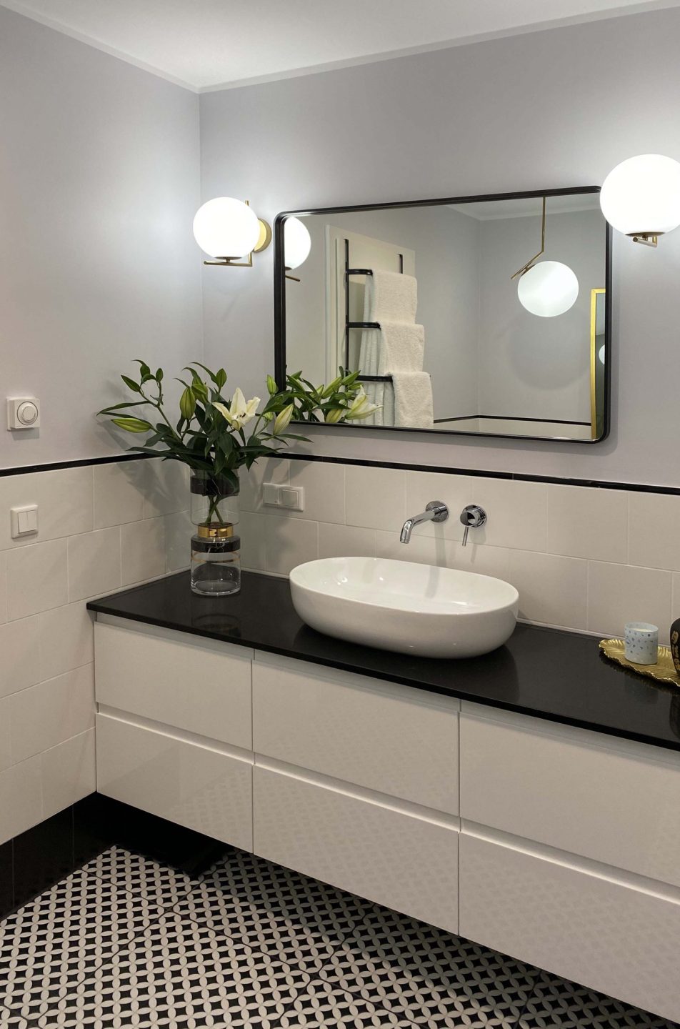 Widok z prawej strony na lustro Tray Black powieszone poziomo w łazience